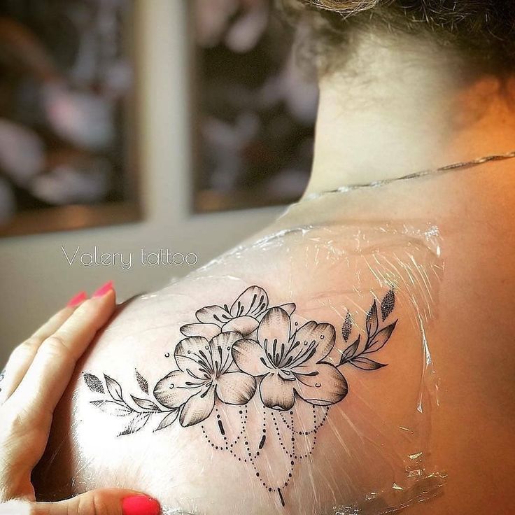 the back of a woman's shoulder with flowers on it