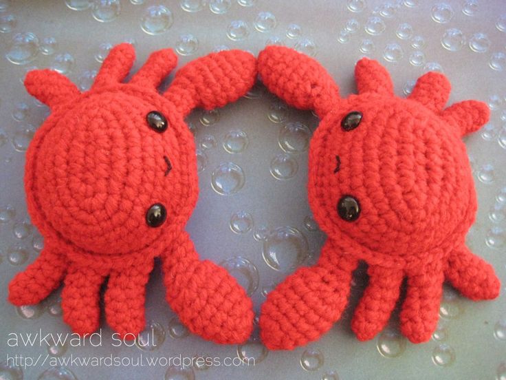 two red crocheted animals sitting on top of a table