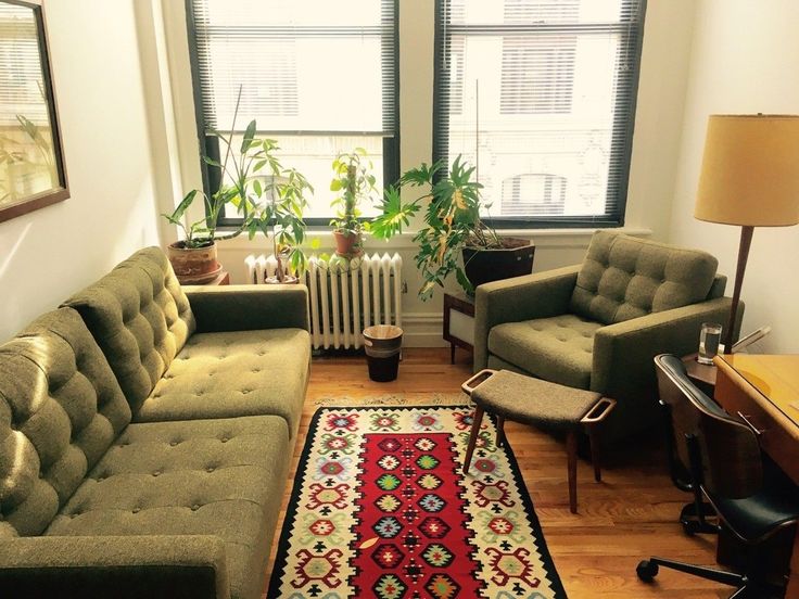 a living room with two couches and a rug in front of a window on the floor