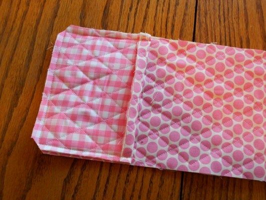 two pieces of fabric sitting on top of a wooden table