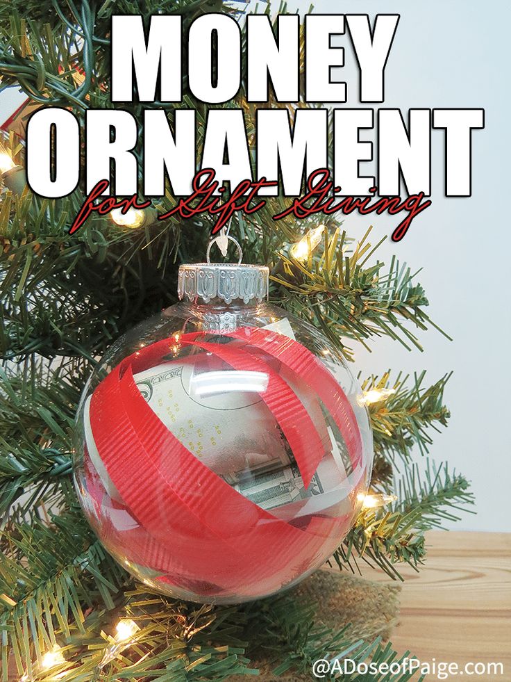 a red and white ornament hanging from a christmas tree with the words money ornament on it