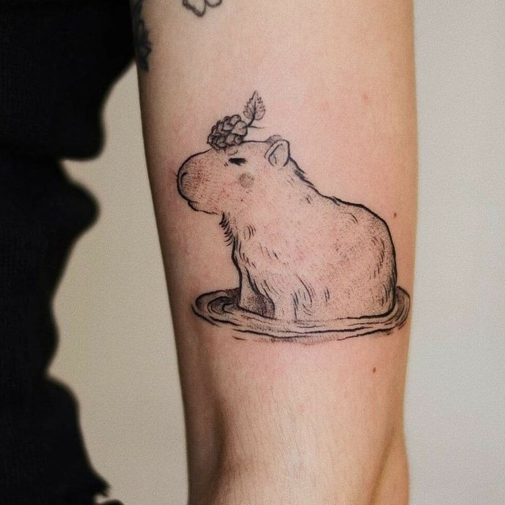 a person with a tattoo on their arm has a drawing of a capybara