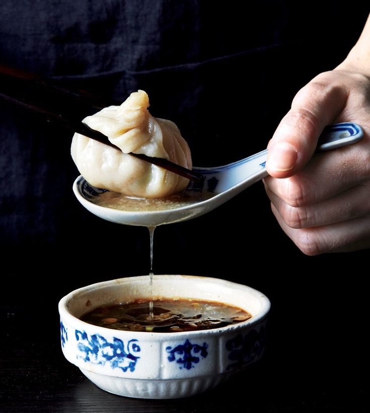 a person is spooning soup out of a bowl