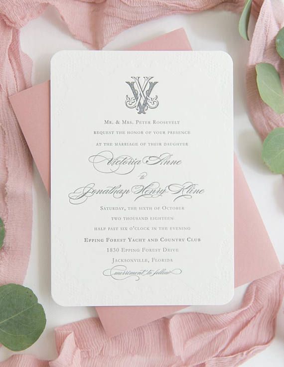 the wedding stationery is laid out on top of pink and white paper with greenery