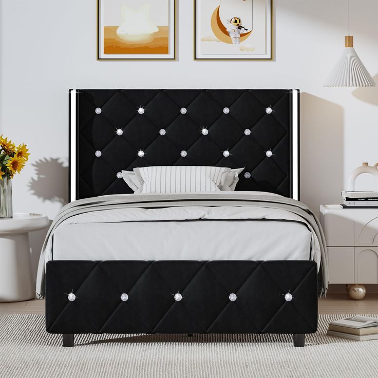 a black and white bed in a room with pictures on the wall