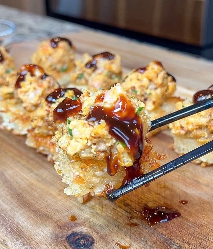 chopsticks picking up food from a wooden cutting board