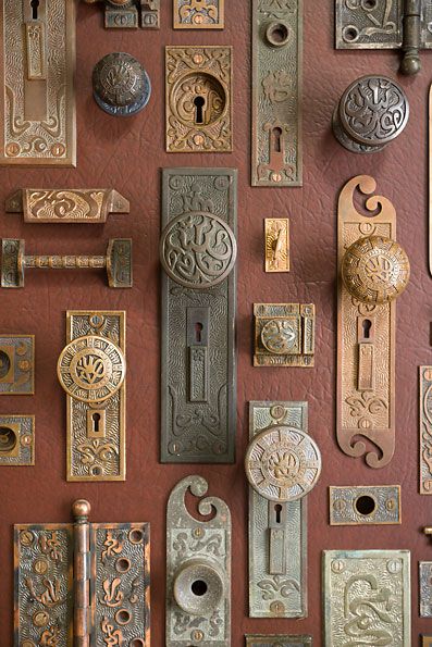 an assortment of door knobs and locks on a red wall