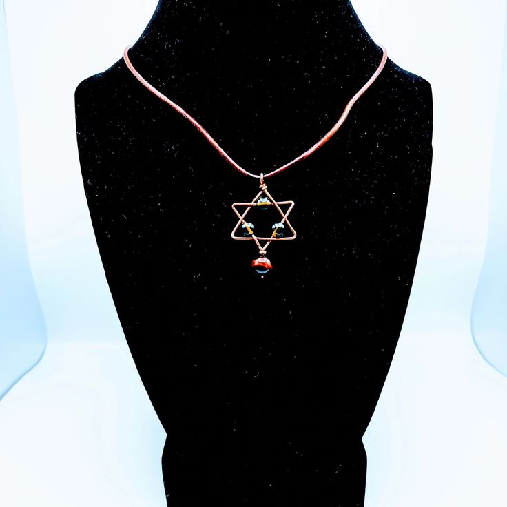 Bathe in the cosmic glow of this "Star-born" necklace! 💫 Witness the transformation with Moldavite and Red Tigers Eye, two powerful stones that bring connectivity, intensity, and talismanic protection. 🛡️ With this necklace, power up your cosmic vibrations and gear up for a space-age transformation! 🚀 Red Birthstone Necklace For Spiritual Purposes, Handmade Spiritual Birthstone Pendant Necklace, Spiritual Round Pendant Charm Necklace For Healing, Wire Wrapped Star Shaped Jewelry Gift, Spiritual Healing Charm Necklaces With Round Pendant, Amber Copper Necklace For Healing, Spiritual Red Birthstone Necklace, Spiritual Wire Wrapped Charm Necklaces For Healing, Spiritual Necklaces With Star Charm As Gift