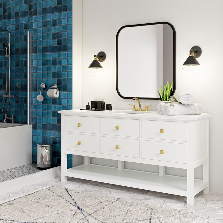 a bathroom with blue tiles and white furniture in the shower area, along with a large mirror on the wall