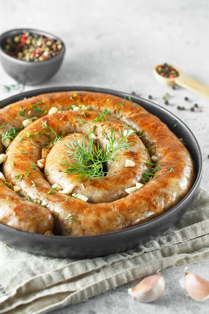 some food is in a pan on a table next to garlic and other ingredients for the dish