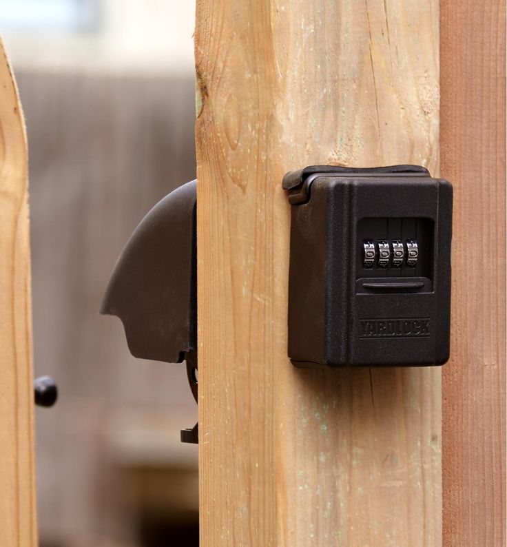 a combination lock attached to a wooden fence