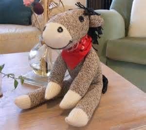 a stuffed animal sitting on top of a wooden table next to a vase filled with flowers