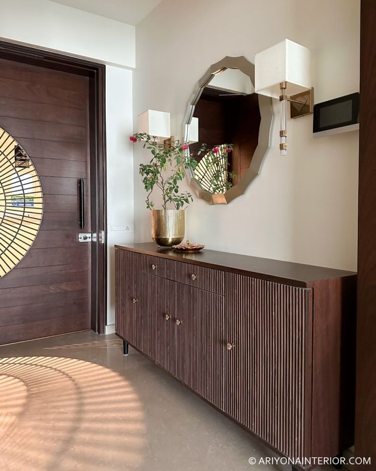 a room with a large mirror and a wooden cabinet in the corner next to a door