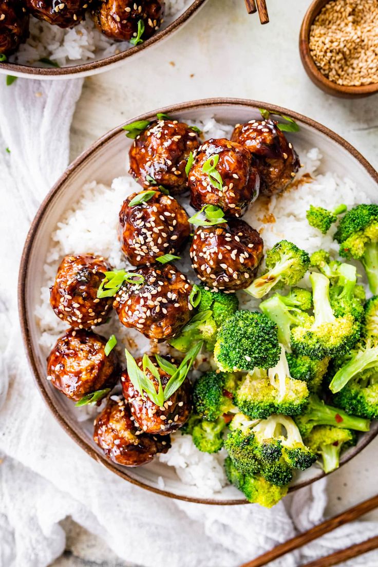 meatballs and broccoli served on rice with chopsticks