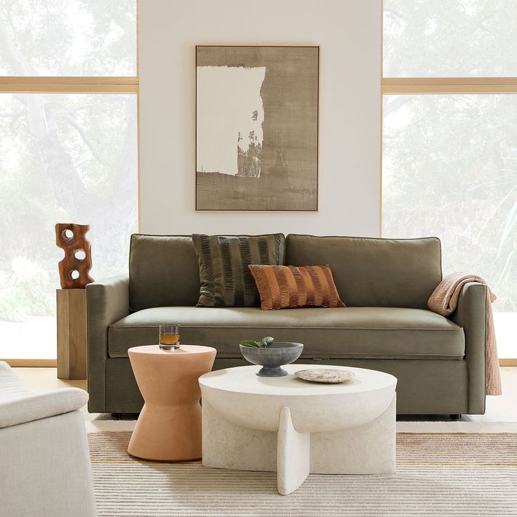 a living room with couches, tables and pictures hanging on the wall above them