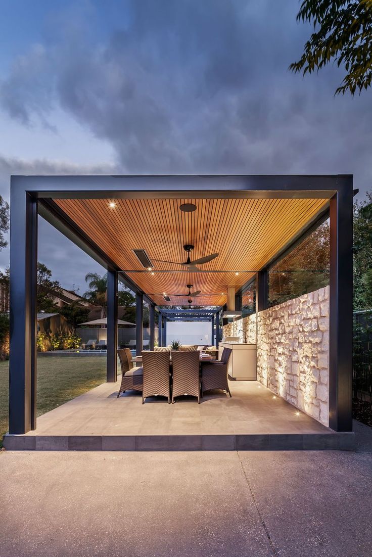 an outdoor covered patio with table and chairs