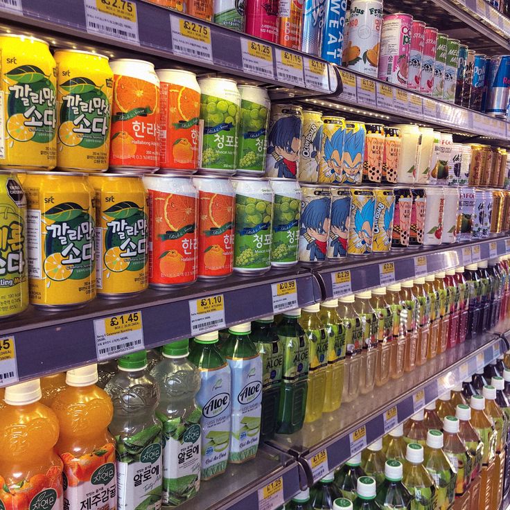 many different types of drinks are on display in a grocery store, including orange juice and green tea