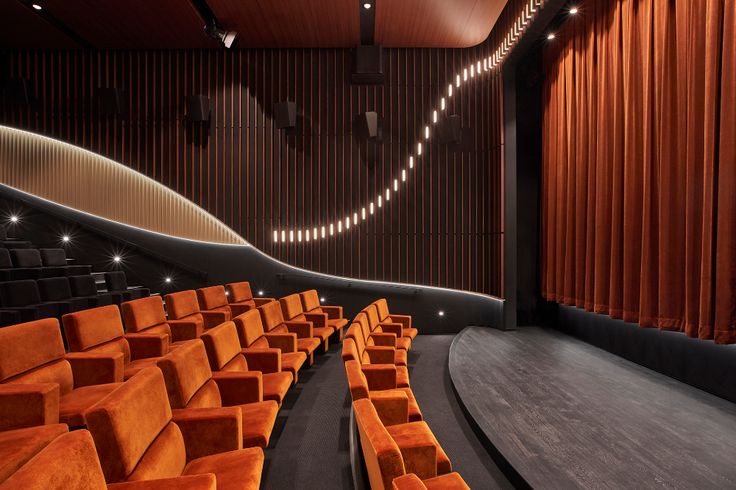 an empty auditorium with rows of orange seats