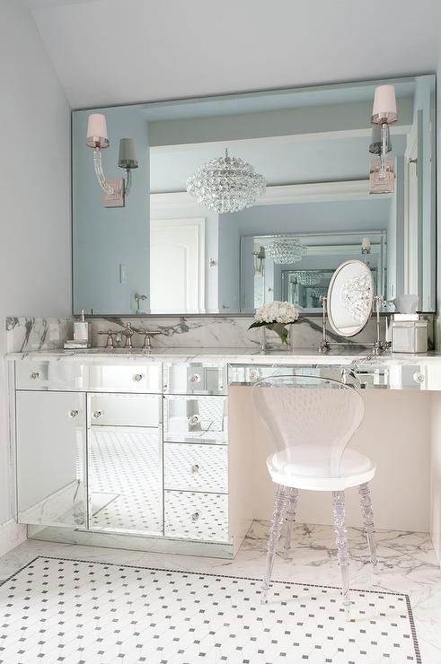 a white chair sitting in front of a large mirror on top of a bathroom counter