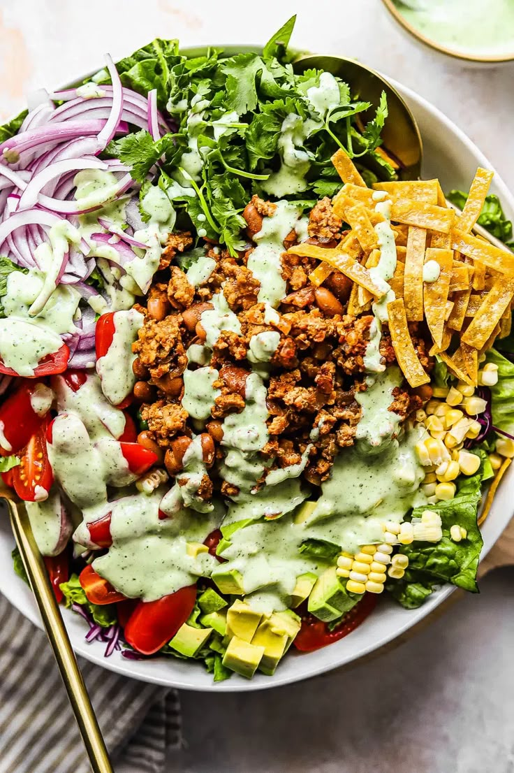 a large bowl filled with taco salad and dressing