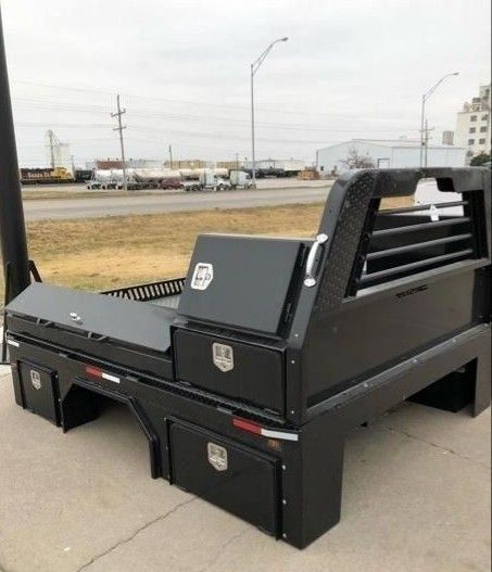 a black truck bed sitting on the side of a road