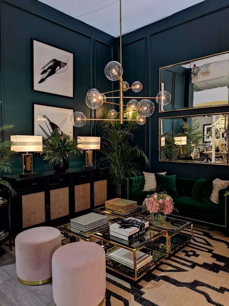 a living room filled with green furniture and lots of mirrors on the wall above it