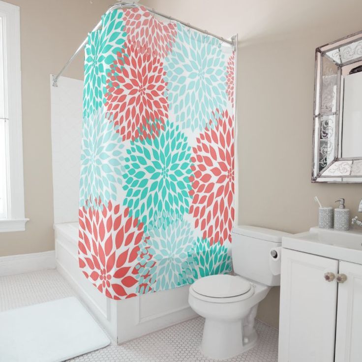 a colorful shower curtain in a bathroom with white fixtures and tile flooring on the walls