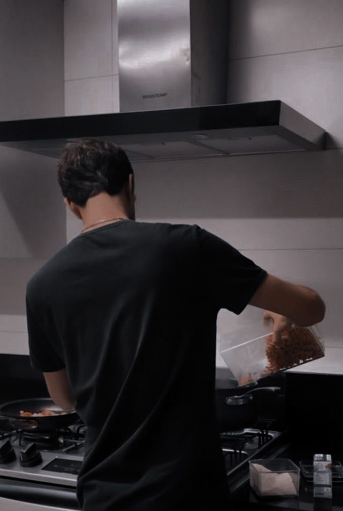 a man standing in front of a stove cooking food on top of an oven burner