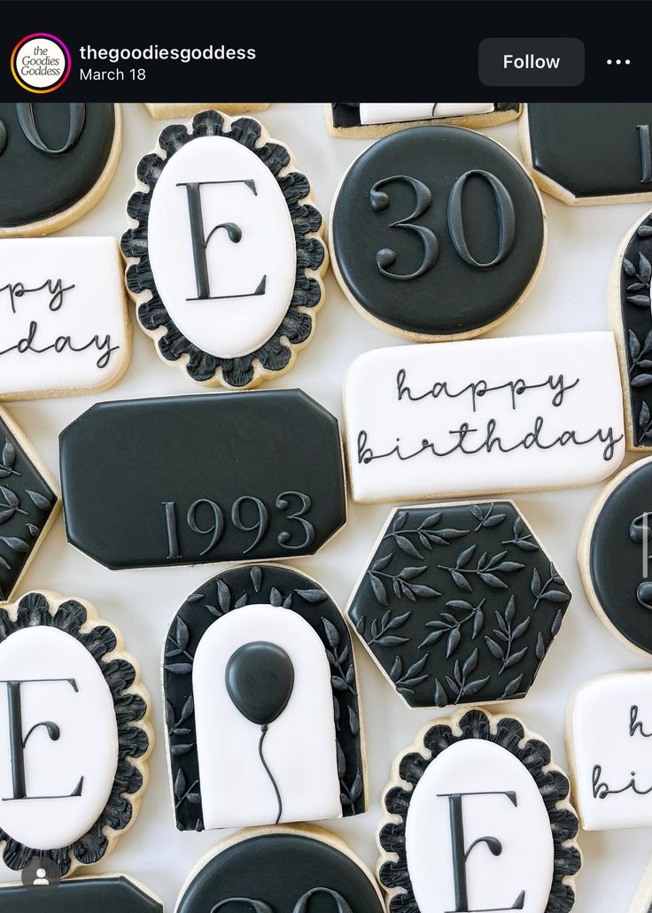 decorated cookies with black and white icing are arranged in the shape of he letters