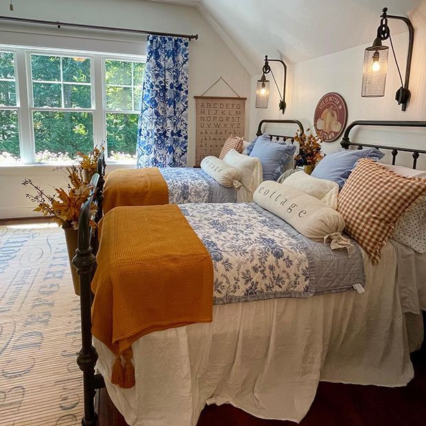 two beds in a bedroom with blue and white decor