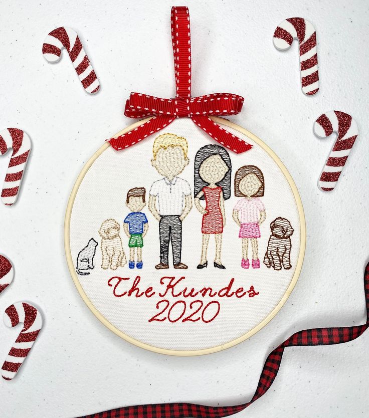 a cross stitch ornament hanging on a wall with candy canes around it