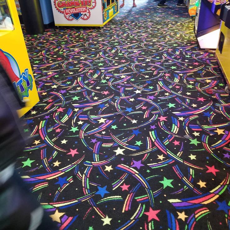 a brightly colored carpet with stars and swirls on the floor in a store aisle