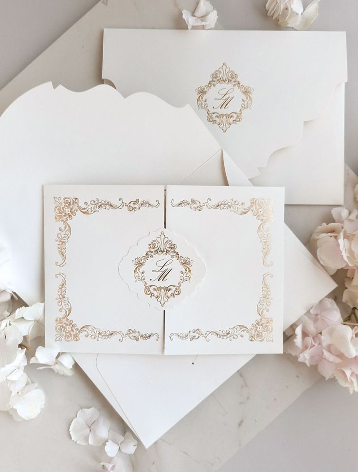 the wedding stationery is laid out on top of each other with flowers around it