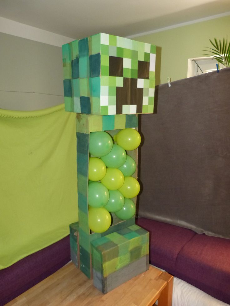 a room decorated in minecraft style with balloons on the wall and a couch behind it