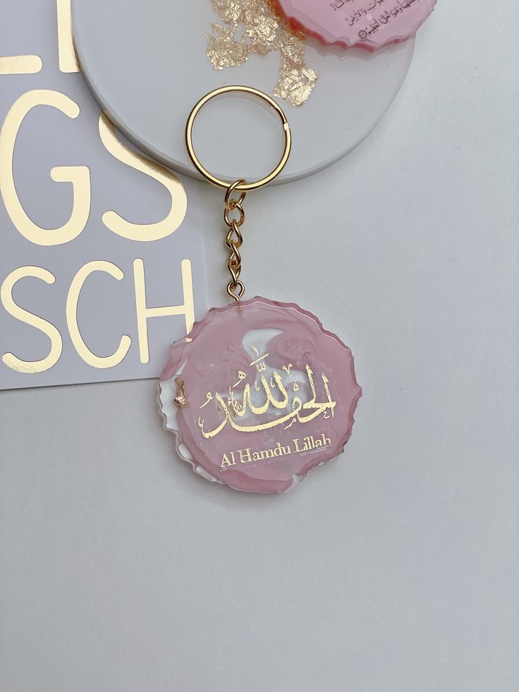 a pink bottle cap shaped keychain sitting on top of a white plate