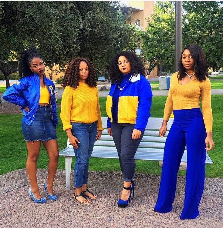 four women standing in front of a park bench