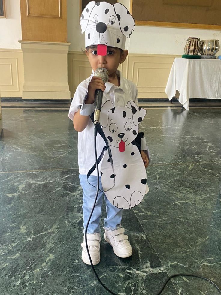 a little boy wearing a dalmatian costume and holding a microphone in his mouth