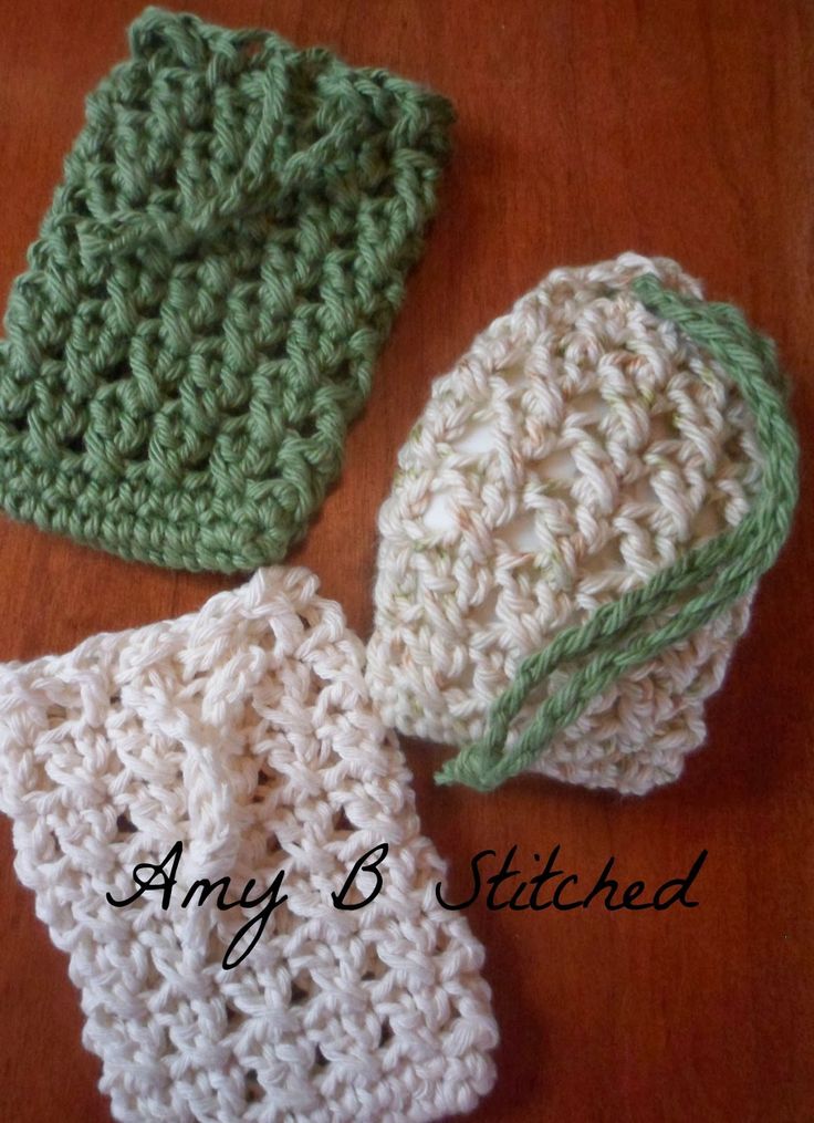 three crocheted dishcloths sitting on top of a wooden table