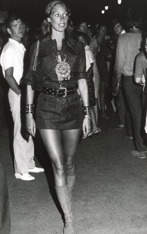 a black and white photo of a woman in short shorts