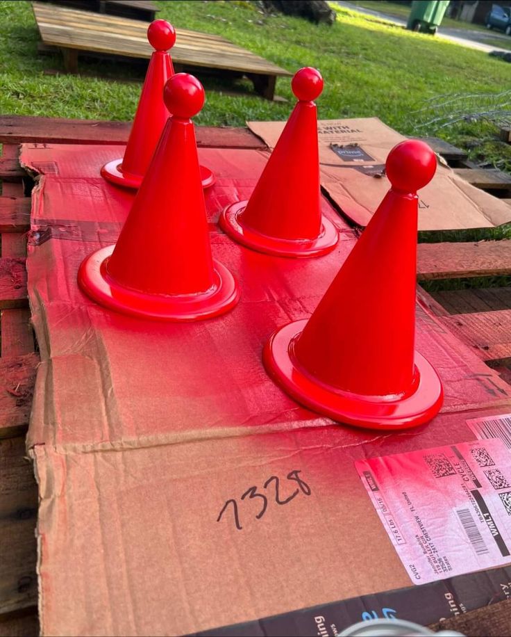 three red cones sitting on top of a cardboard box