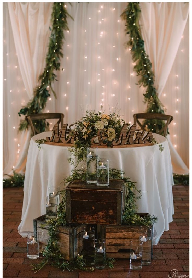 the table is covered with greenery and candles