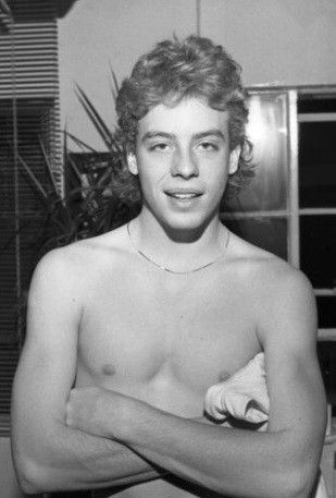 black and white photograph of a young man with his arms crossed