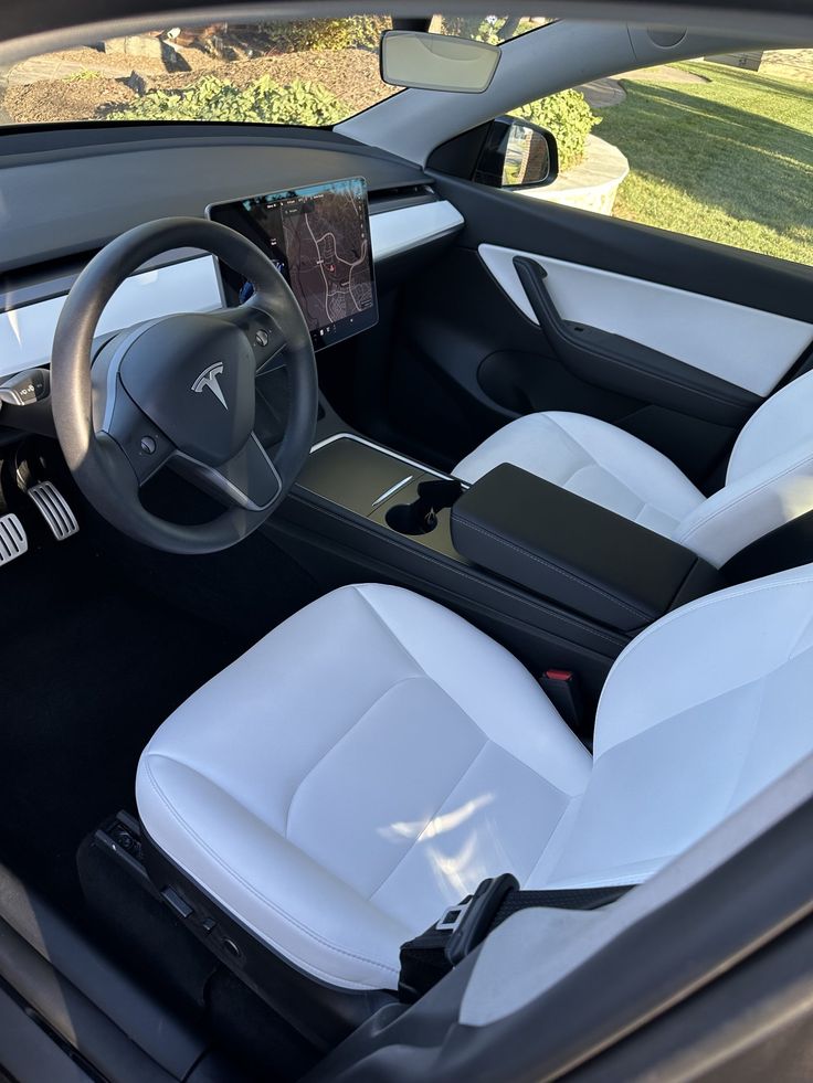 the interior of a modern car with white leather seats and black dash board on display