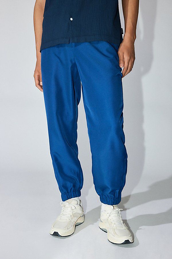 Warm up track pants by Standard Cloth. Tapered fit pants with a stretch waistband and ankle cuffs. Urban Outfitters exclusive. Features Standard Cloth warm up track pant Athletic track pants Mid rise waist Elastic waistband Tapered fit Elastic ankle cuffs UO exclusive Content + Care 100% Polyester Machine wash Imported Size + Fit Model in Black is 6’2" and wearing size Medium Measurements taken from size Medium Rise: 12" Inseam: 27" Leg opening: 6" | Standard Cloth Warm Up Track Pant in Navy, Men's at Urban Outfitters Sports Sweatpants With Pockets And Tapered Leg, Sports Tapered Leg Sweatpants With Pockets, Tapered Leg Sweatpants With Pockets For Sports, Moisture-wicking Tapered Leg Sweatpants For Jogging, Athleisure Joggers With Elastic Waistband And Cuffed Ankles, Athleisure Sports Bottoms With Ribbed Cuffs, Sportswear Pants With Ribbed Cuffs For Sports, Sporty Joggers With Relaxed Fit And Cuffed Ankles, Sporty Stretch Joggers With Cuffed Ankles