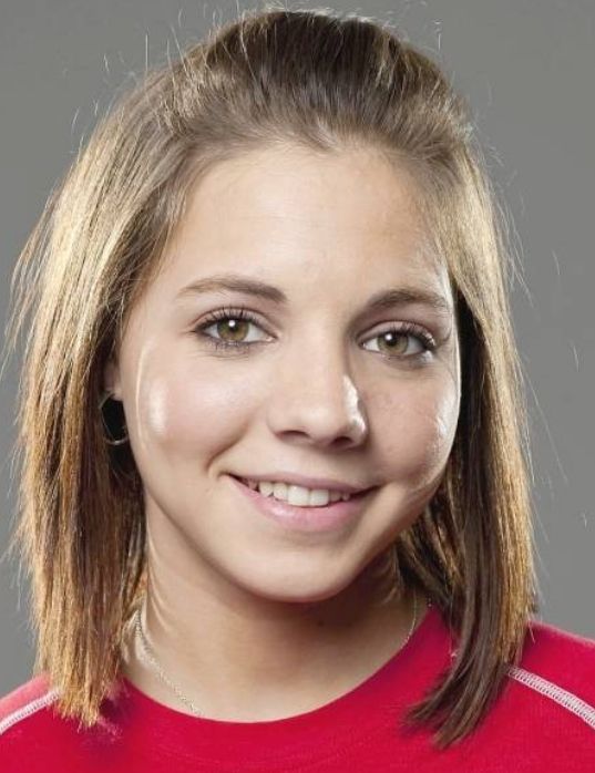 a young woman with blonde hair smiling at the camera and wearing a red shirt that has white stripes on it