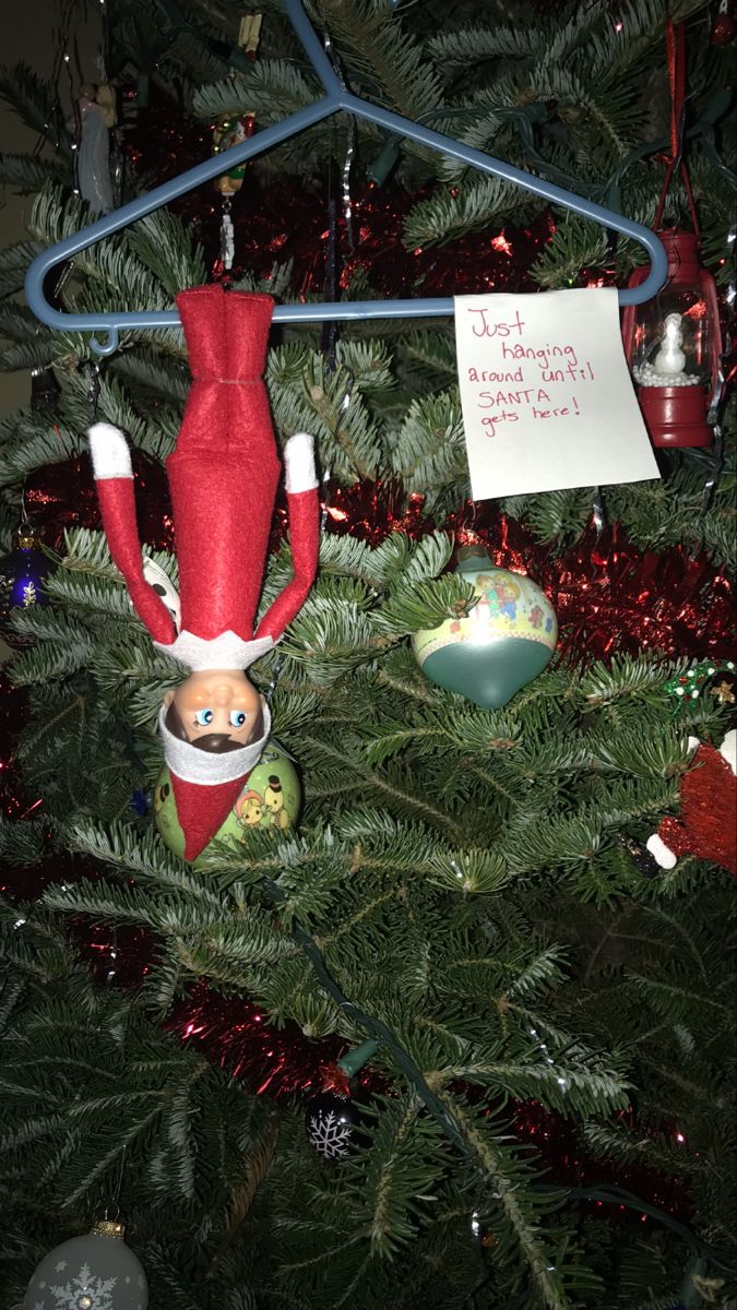 an ornament hanging from the top of a christmas tree with a note attached to it