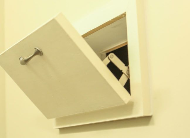 a white cabinet with a door open in a room that looks like it is being used as a storage unit