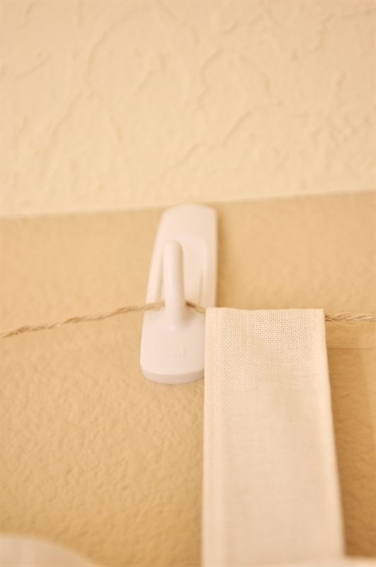 there is a white object hanging on the wall next to a curtain rod and some fabric