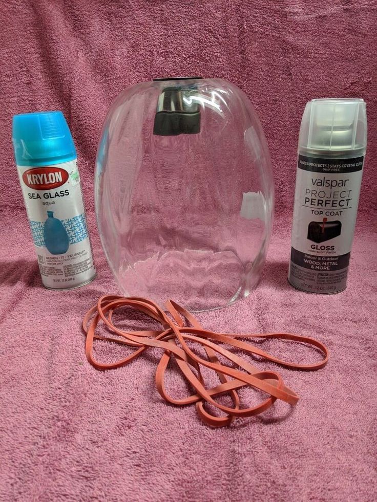 a pair of scissors, glue and other items are on a pink sheeted surface