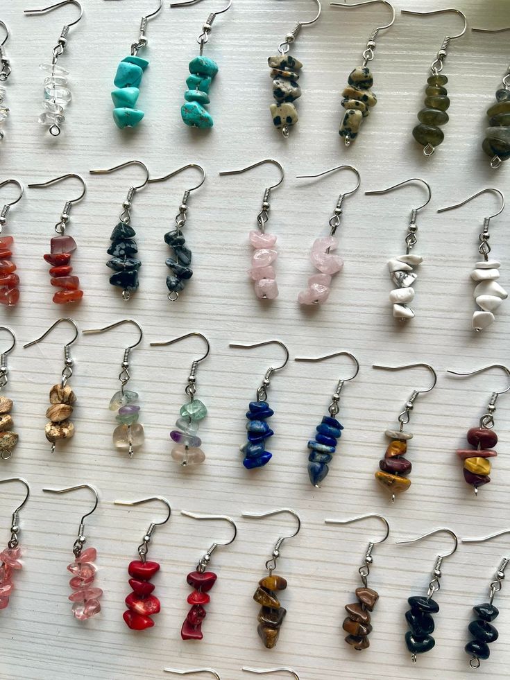 several pairs of earrings are displayed on a table